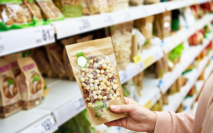 Nüsse in Standbodenbeutel verpackt hält Person in der Hand