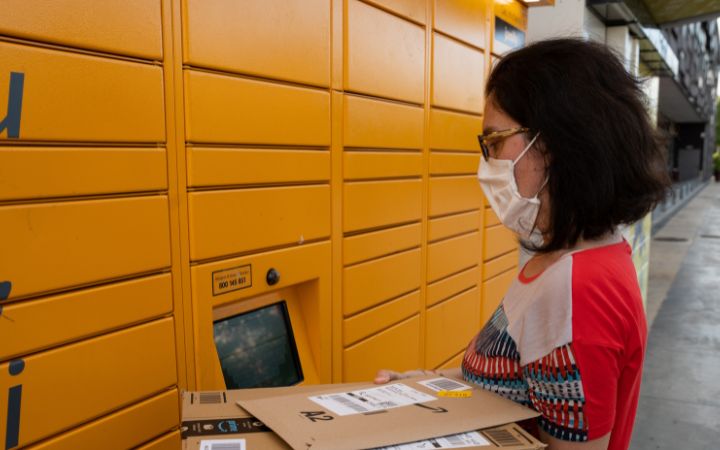 Frau steht an der Packstation